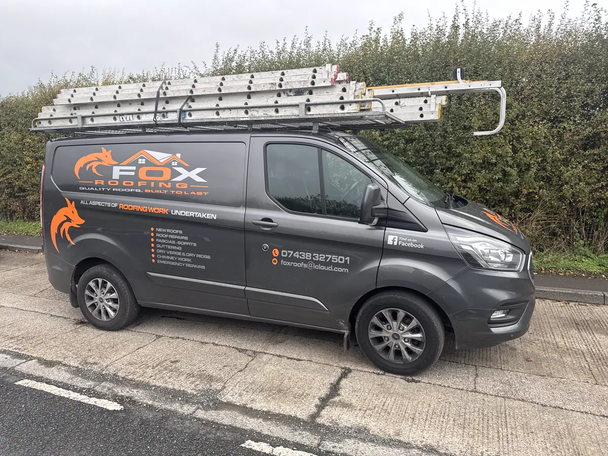 A Fox Roofing van with ladders on the roof rack and every service listed on the side