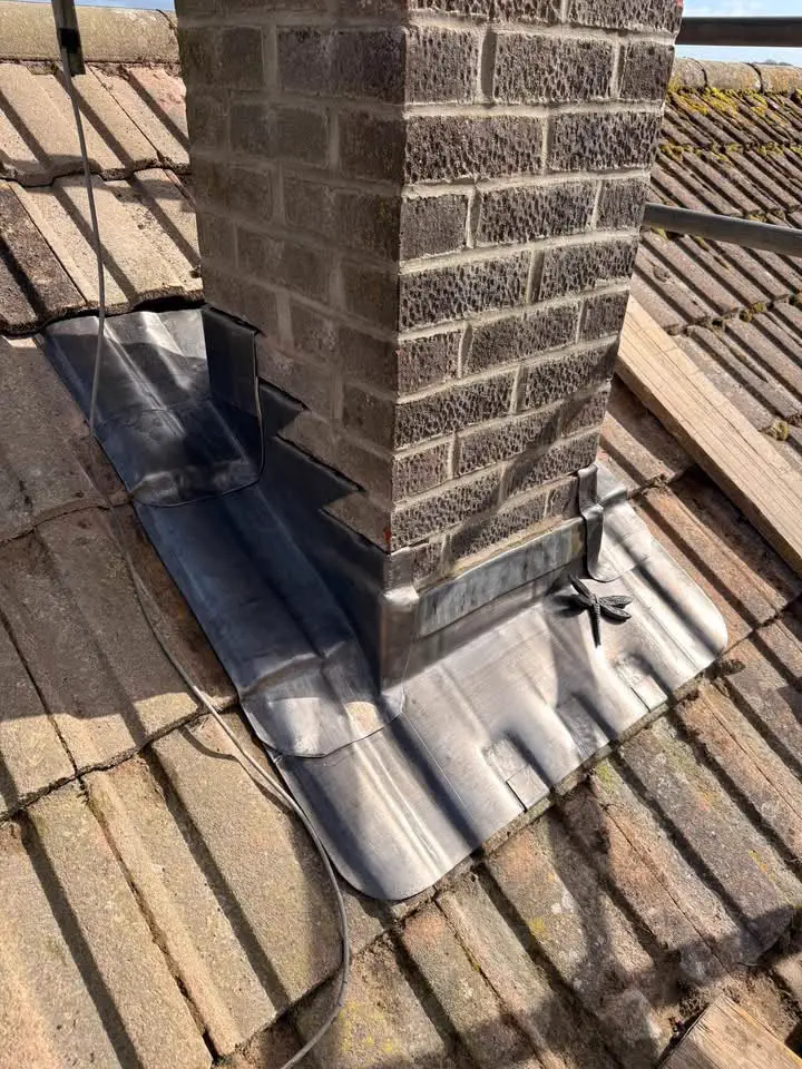 New stepped lead flashing around the base of a brick chimney stack